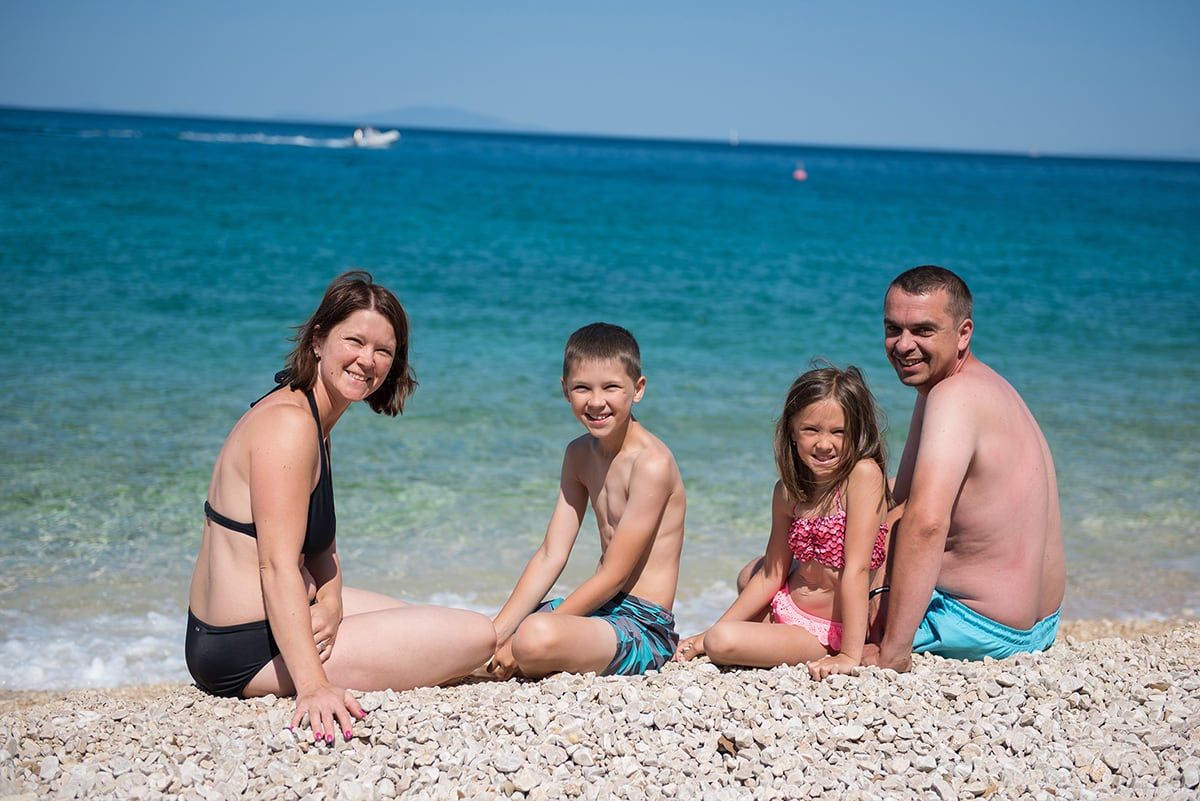 Obitelj s djecom na plaži uz more
