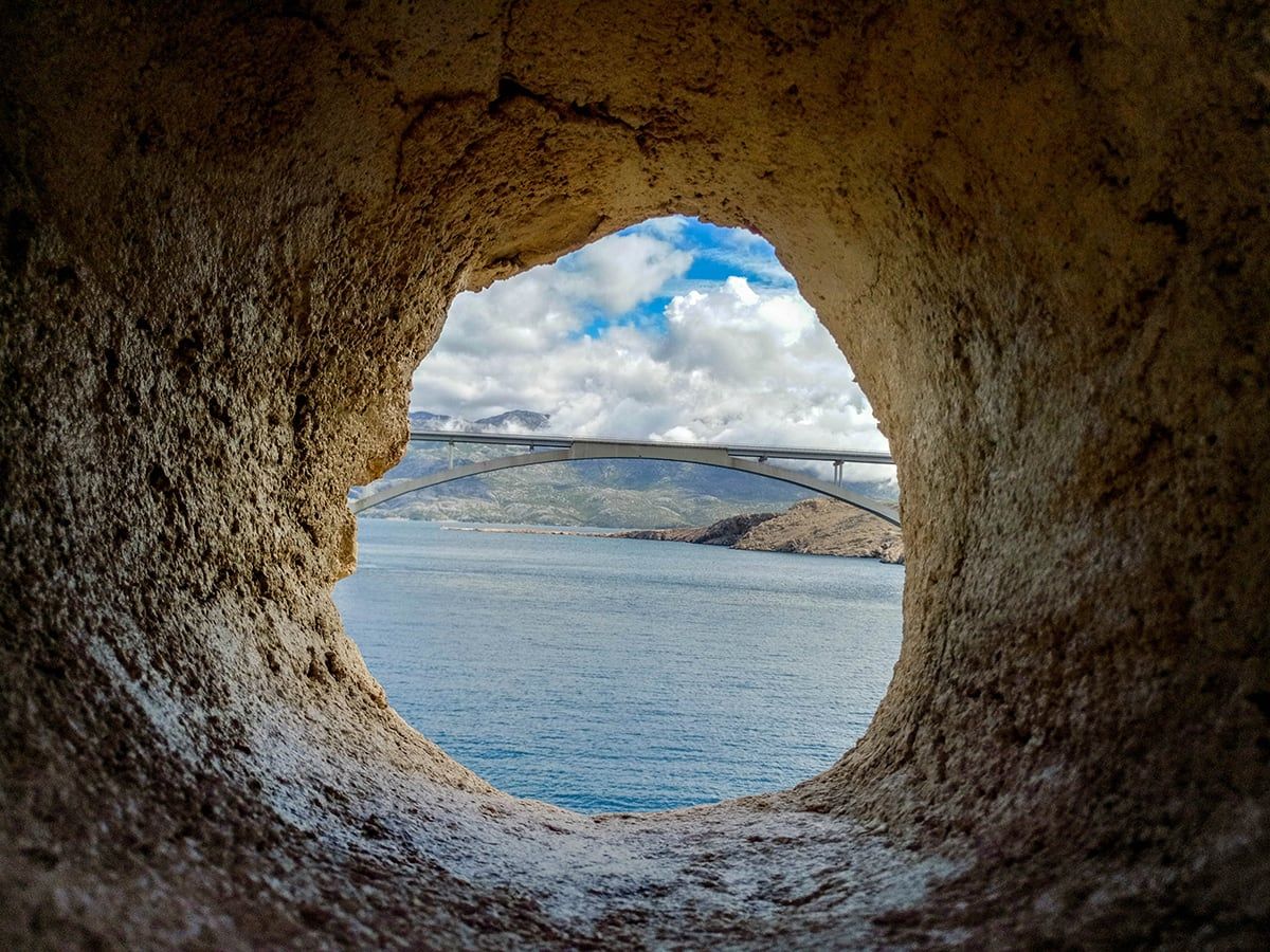Paški most viđen kroz otvor u stijeni